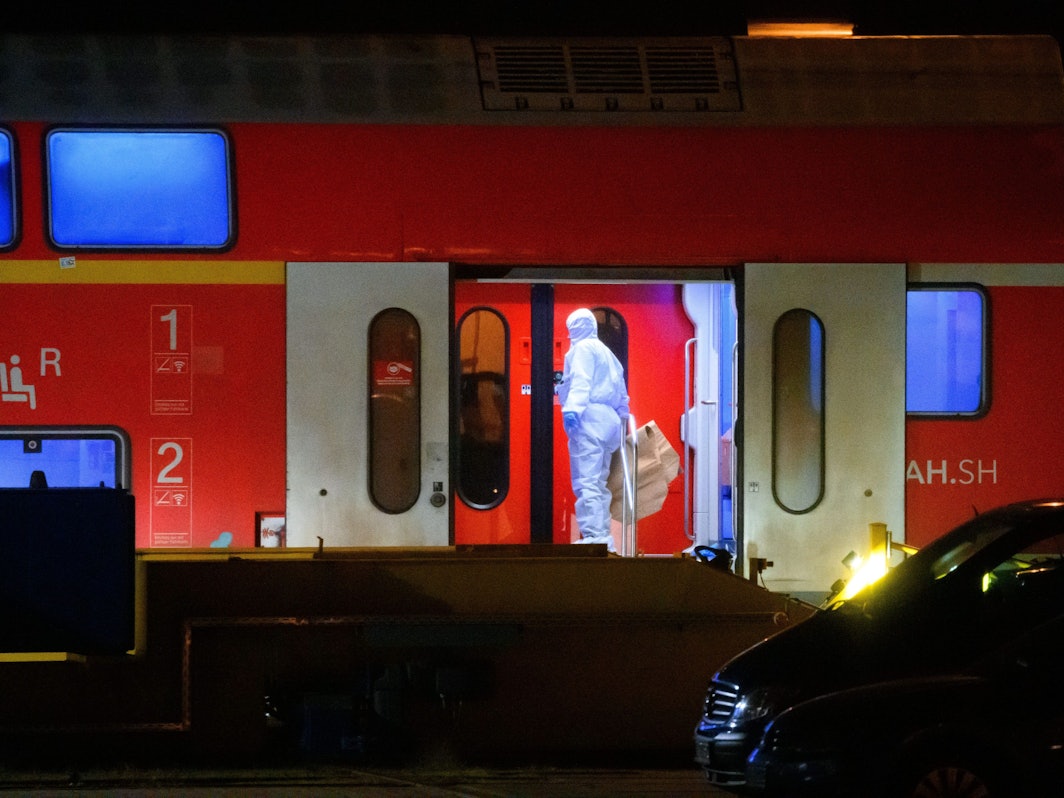 Ein Ermittler im weißen Schutzanzug arbeitet in dem Regionalzug.