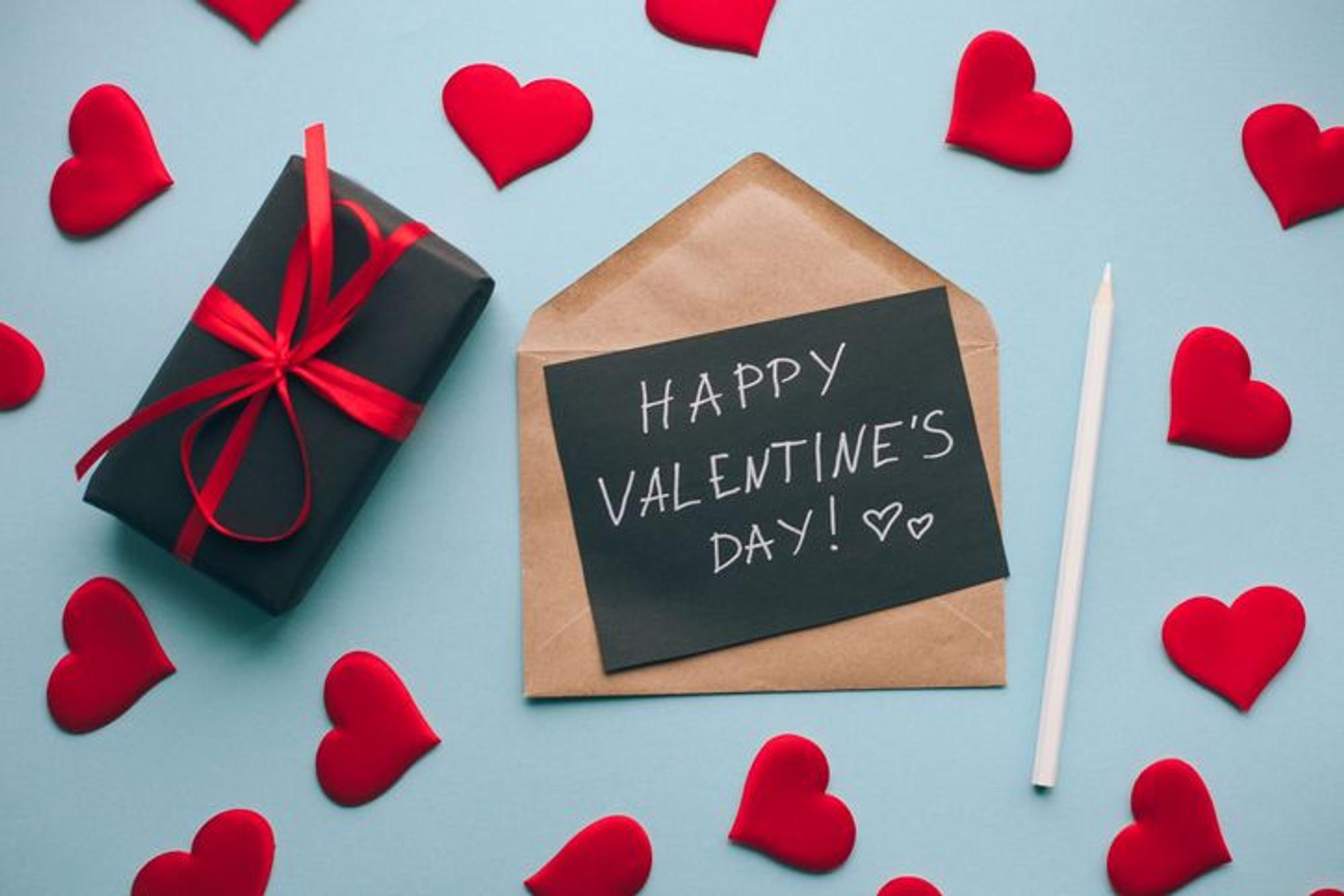 Valentinstagskarte mit handgeschriebenem Text und Gift Box, von roten Herzen umgeben