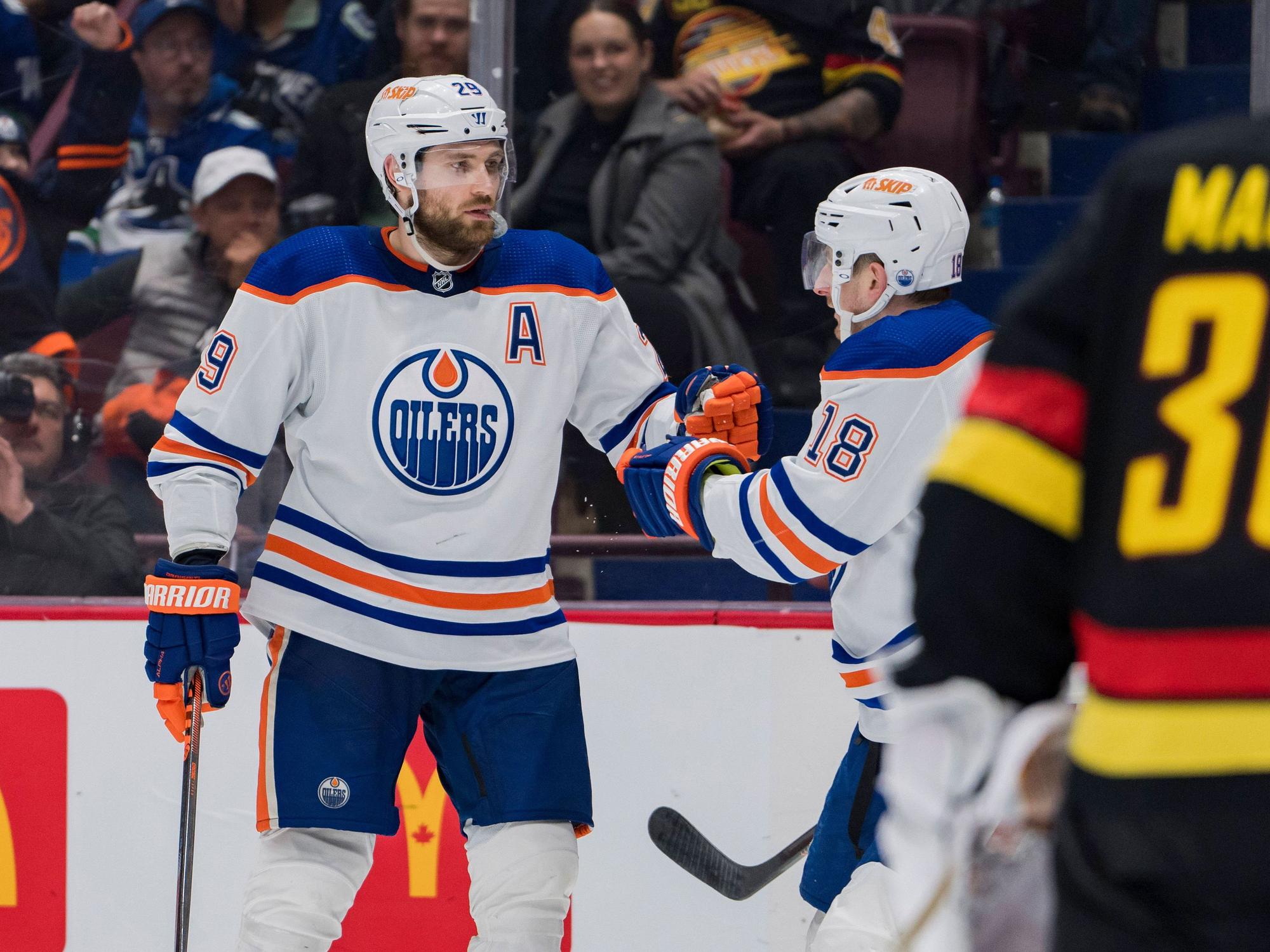 Leon Draisaitl klatscht mit einem Team.Kollegen ab.