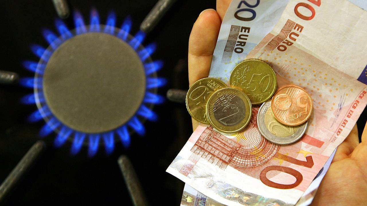 Neben einer brennenden Gasflamme an einem Herd in einer Küche im brandenburgischen Petersdorf (Oder-Spree) hält eine Frau im Oktober 2006 Geld in der Hand. Sinkende Großhandelspreise für Gas sorgen bei Verbraucherschützern für große Erwartungen.