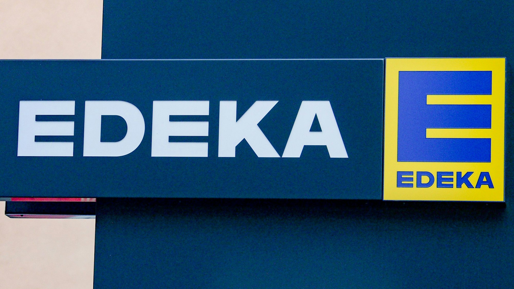 Das Logo von Edeka vor einer Filiale.