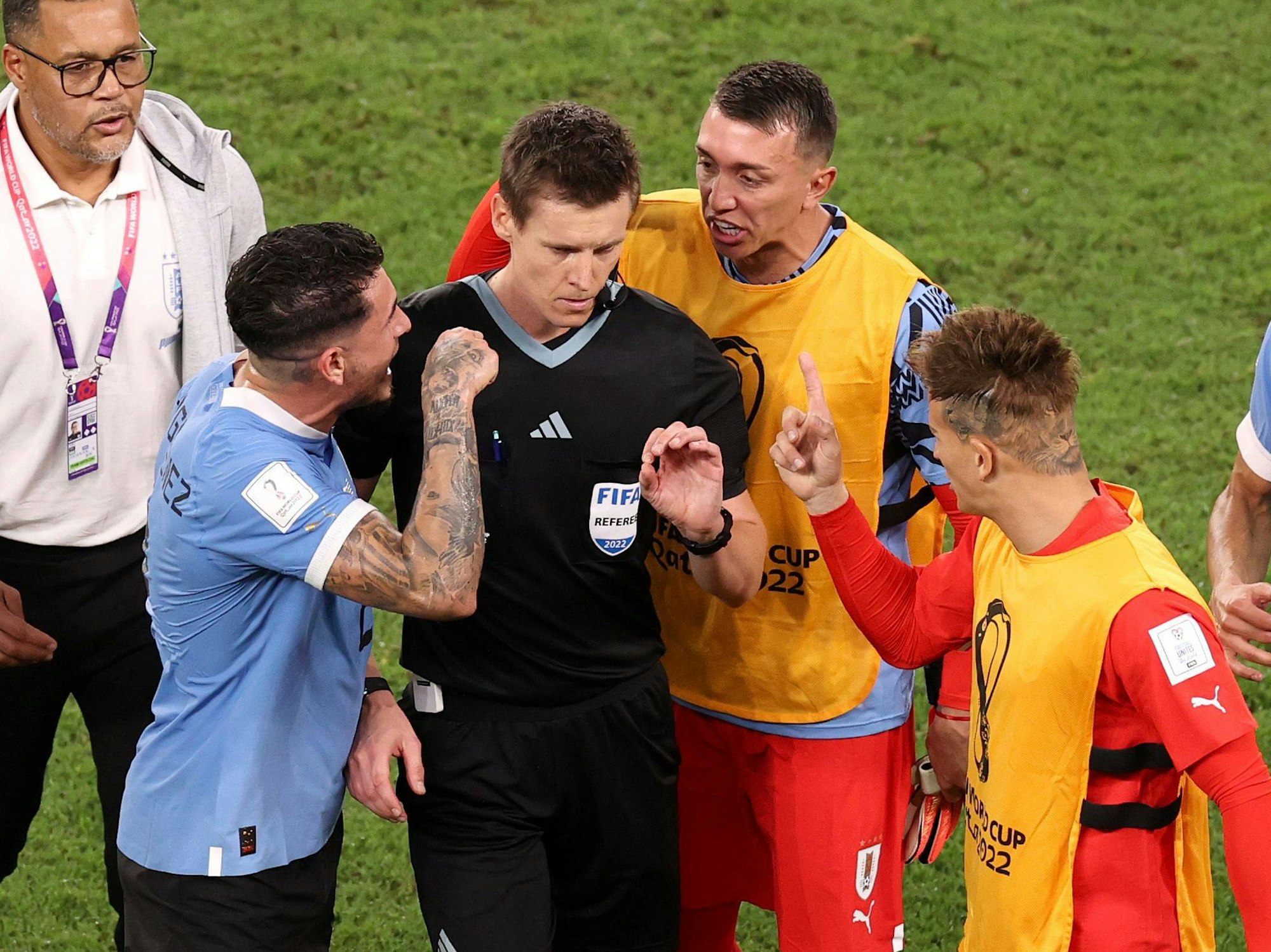 Daniel Siebert wird im Al Janoub Stadium von Urugay-Spielern bedrängt.