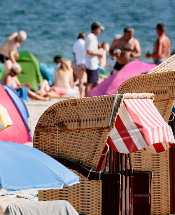 Das undatierte Symbolfoto zeigt Badegäste am Meer und Strandkörbe mit bunten Markisen.