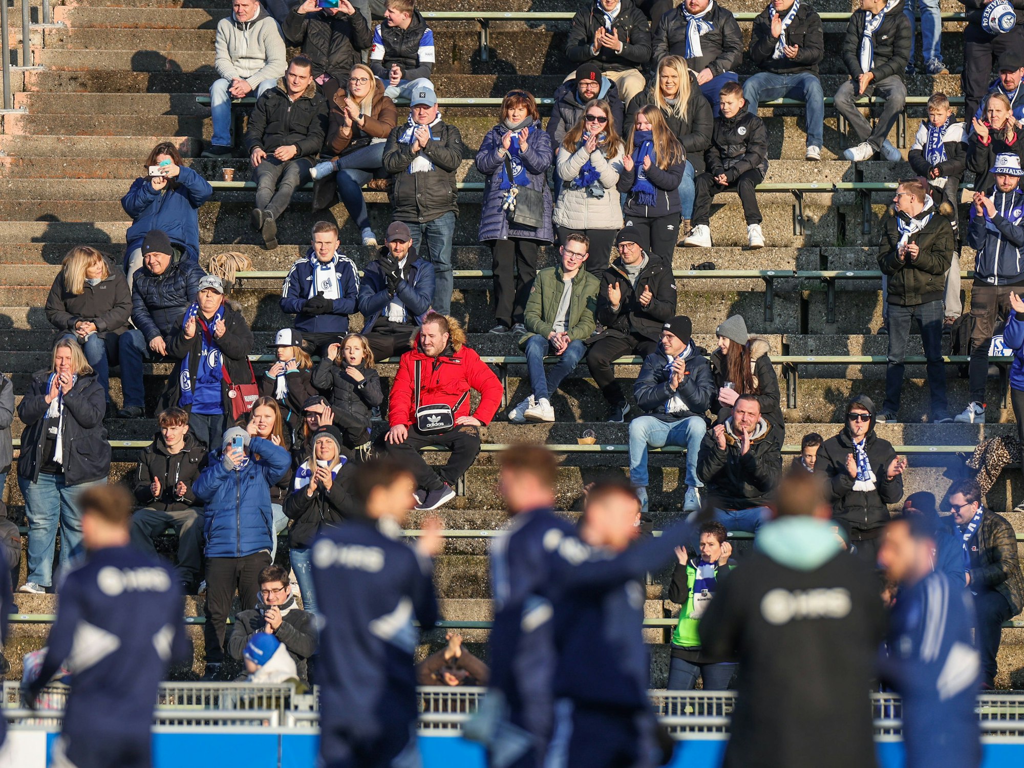 Fans sitzen beim Abschlusstraining des FC Schalke 04 auf der Tribüne des Parkstadions.