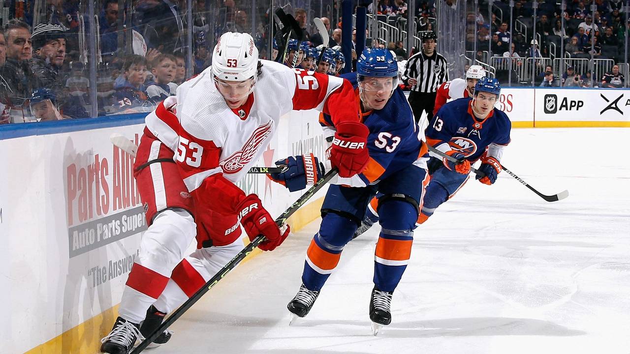 Detroits Moritz Seider (l.) läuft mit dem Puck und wird von Casey Cizikas (M.) verfolgt.