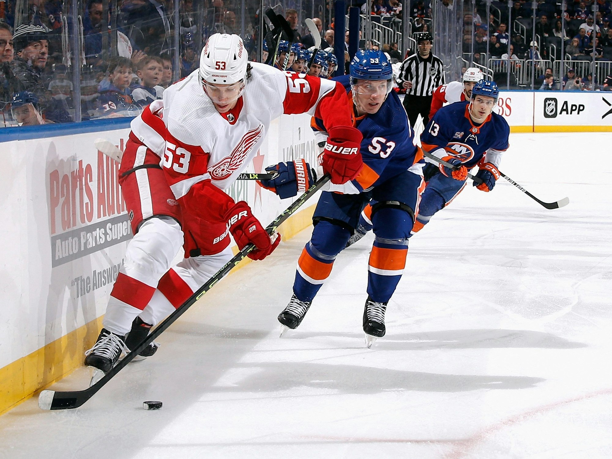 Detroits Moritz Seider (l.) läuft mit dem Puck und wird von Casey Cizikas (M.) verfolgt.
