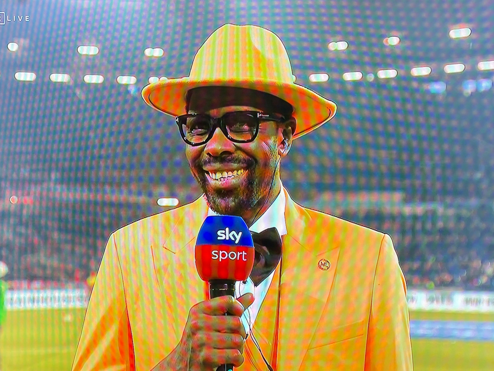 Mo Idrissou steht beim Sky-Interview am Spielfeldrand.