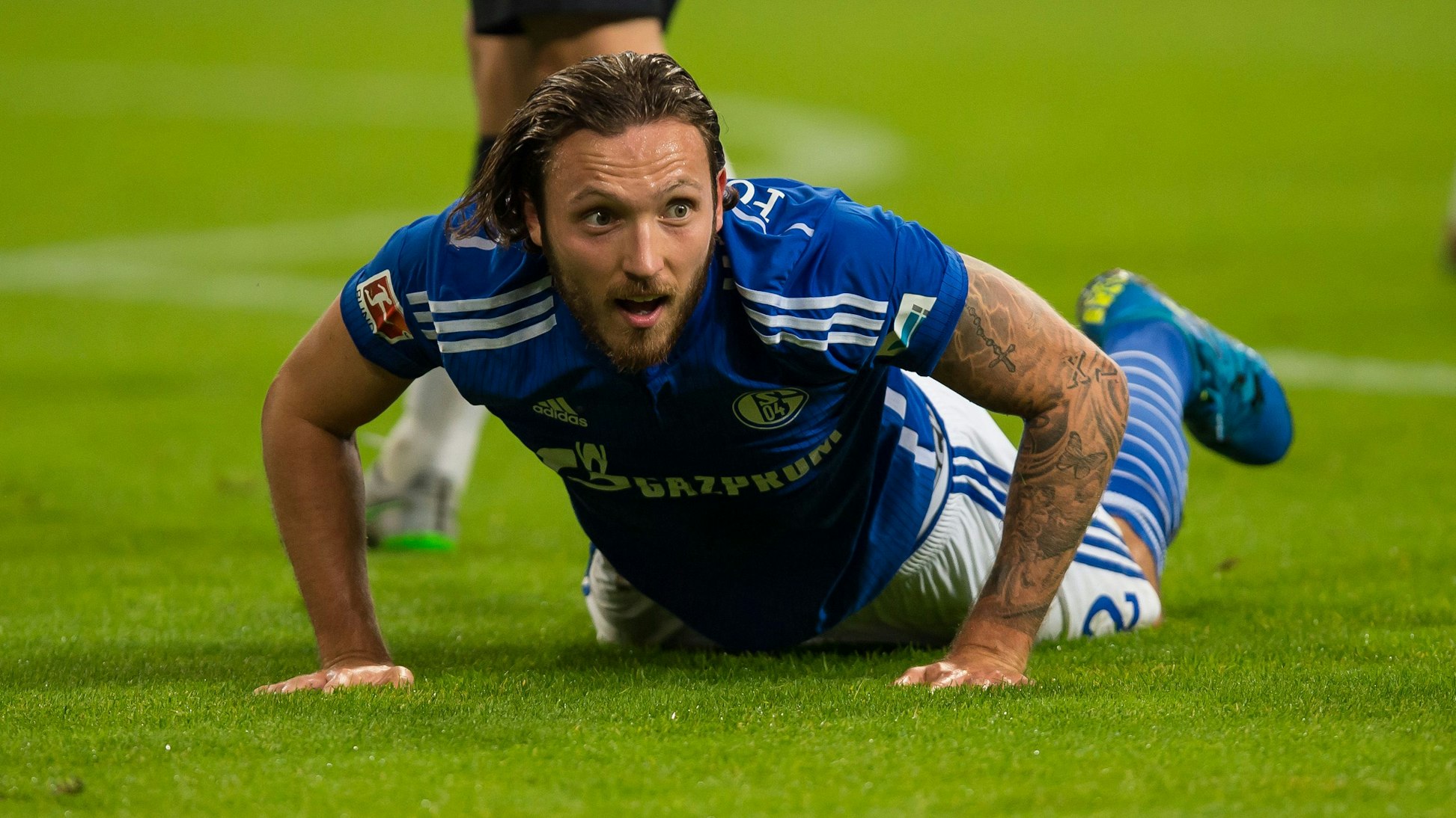 Schalkes Marco Höger liegt nach einem Foul auf dem Rasen.