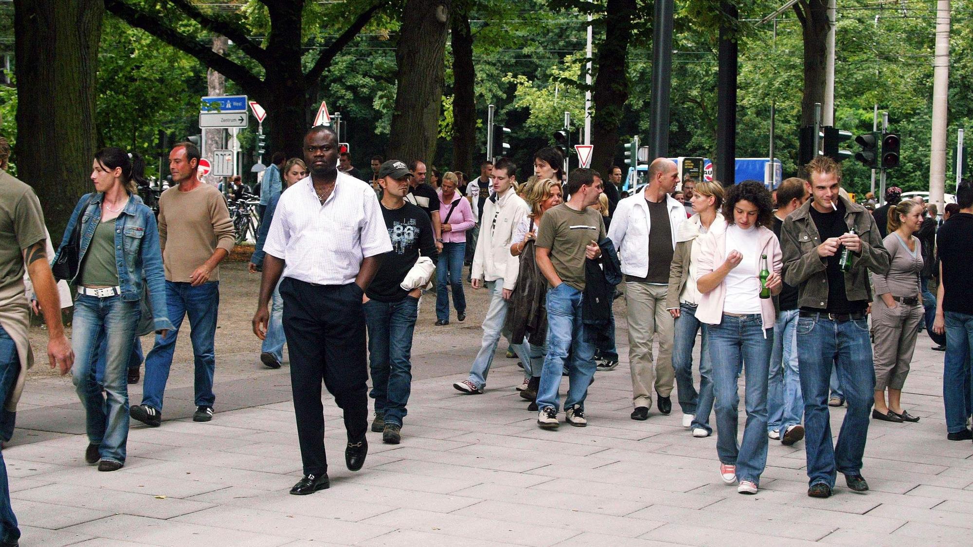 Menschen pilgern 2006 zum XXL-Konzert von Robbie Williams auf der Jahnwiese in Köln.