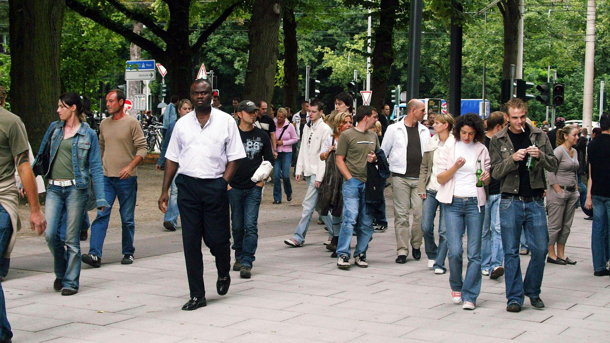 Menschen pilgern 2006 zum XXL-Konzert von Robbie Williams auf der Jahnwiese in Köln.