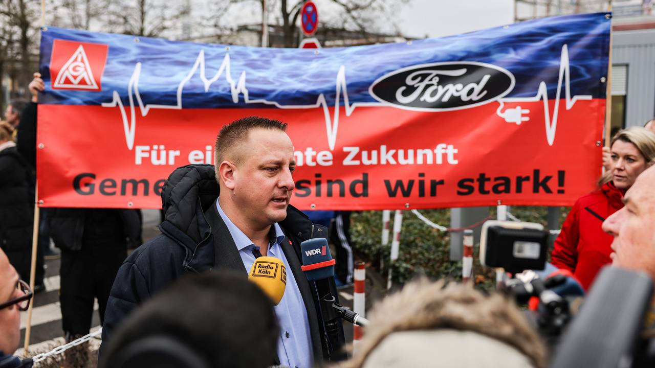 Benjamin Gruschka, Betriebsratsvorsitzender von Ford, spricht vor dem Werksgelände zu Journalisten.
