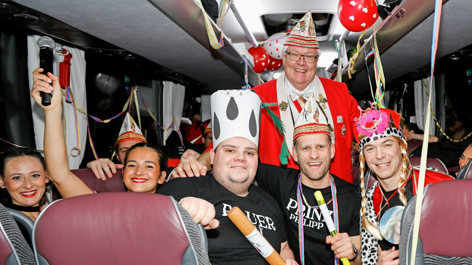 Das Jecke Dreigestirn der Kammerkätzchen und Kammerdiener posiert im Bus.