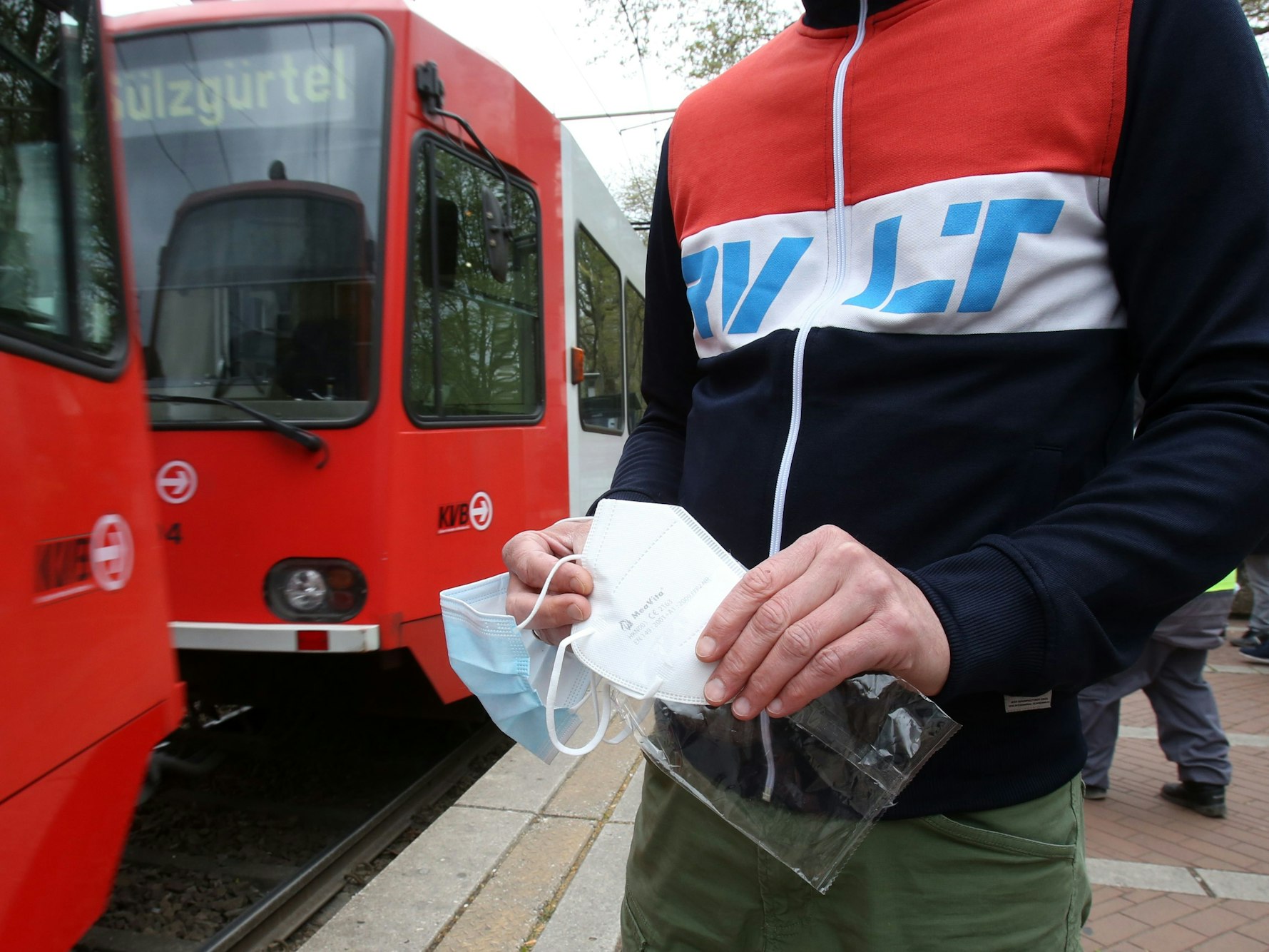 Ein KVB-Kunde hält eine FFP2-Maske in den Händen.