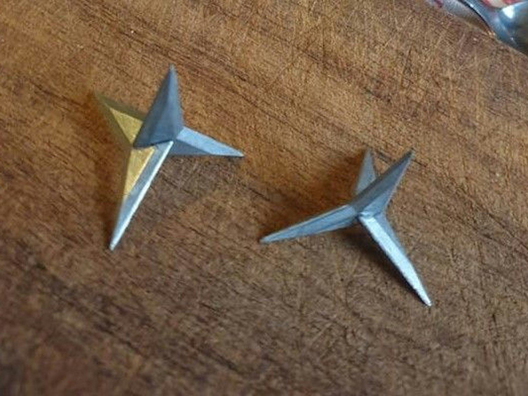 Zwei scharfe Krähenfüße liegen auf einem Tisch.