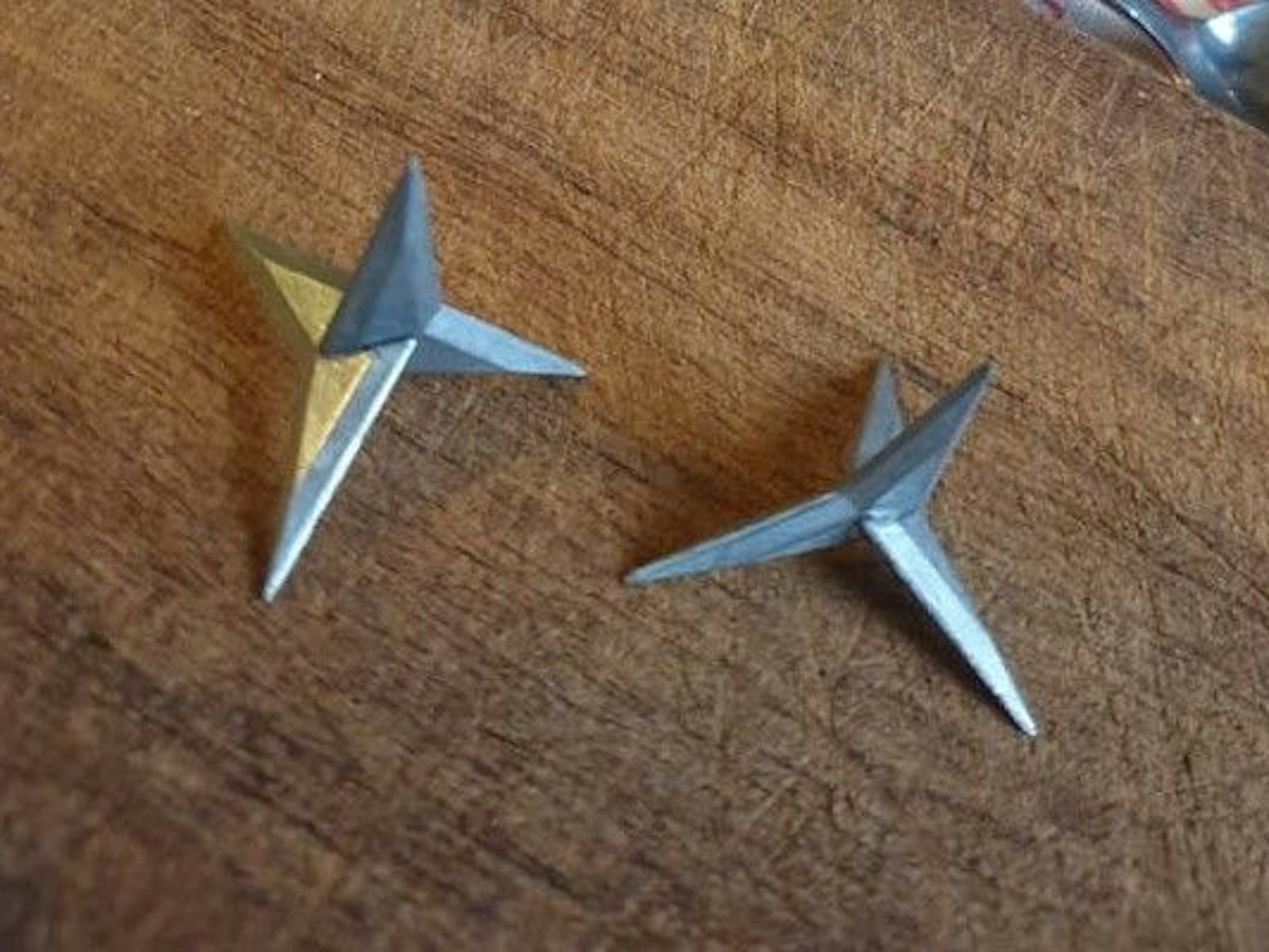 Zwei scharfe Krähenfüße liegen auf einem Tisch.