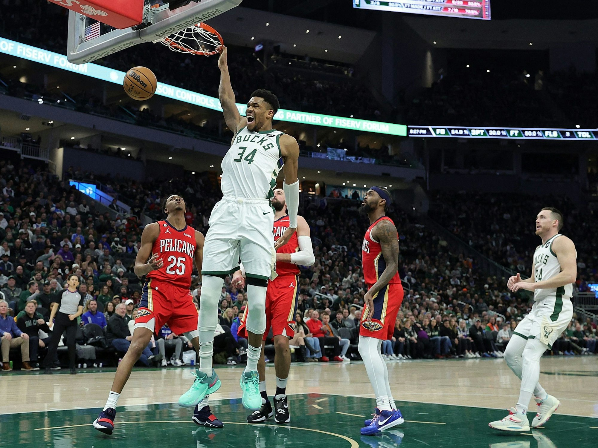 Superstar Giannis Antetokounmpo (M.) trifft für die Bucks per Dunk und jubelt.