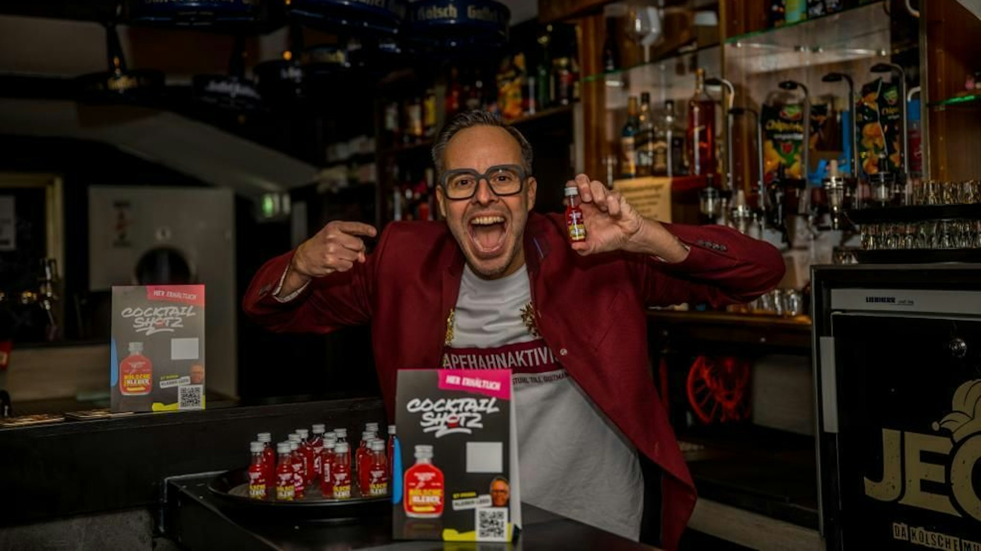 Till Quitmann zeigt die neuen Getränke-Flaschen „Kölscher Kleber“.