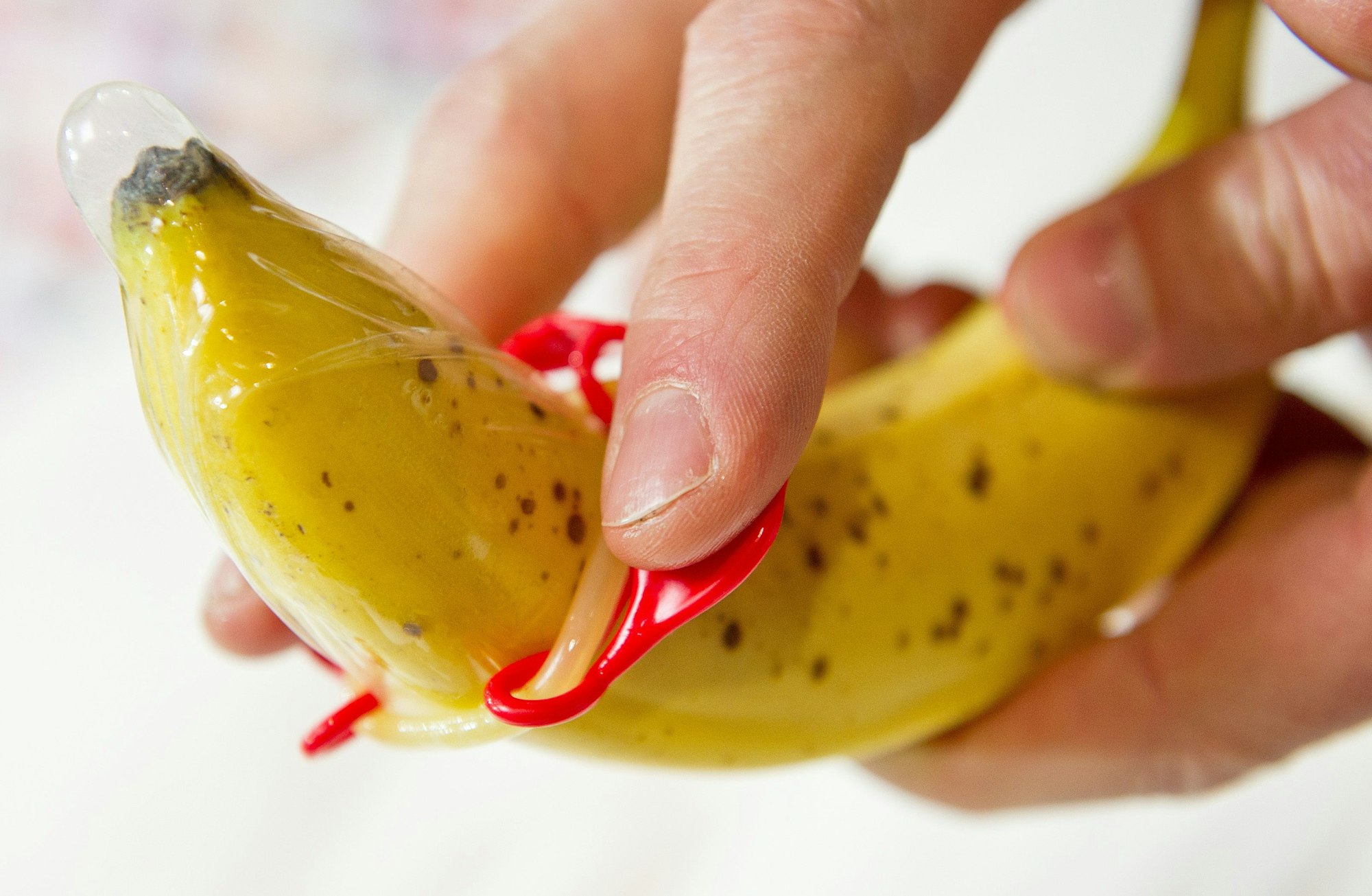 Das Foto aus dem Jahr 2014 zeigt eine Banane, über die ein Kondom gezogen wird.