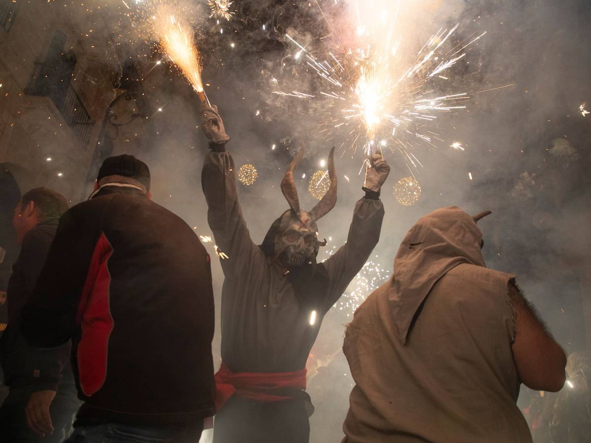 Ein als Dämon verkleideter Mann, der ein Feuerwerk in der Hand hält, läuft während des traditionellen Correfoc zum Abschluss des alljährlichen Stadtfestes zu Ehren des Stadtheiligen Sant Sebastià (Heiliger Sebastian) unter den Menschen.