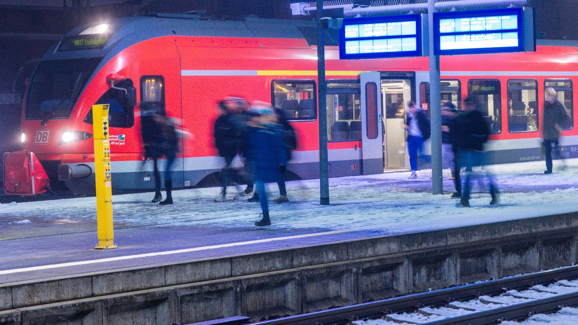 Fahrgäste steigen an einem Bahnhof aus einem Regionalzug.