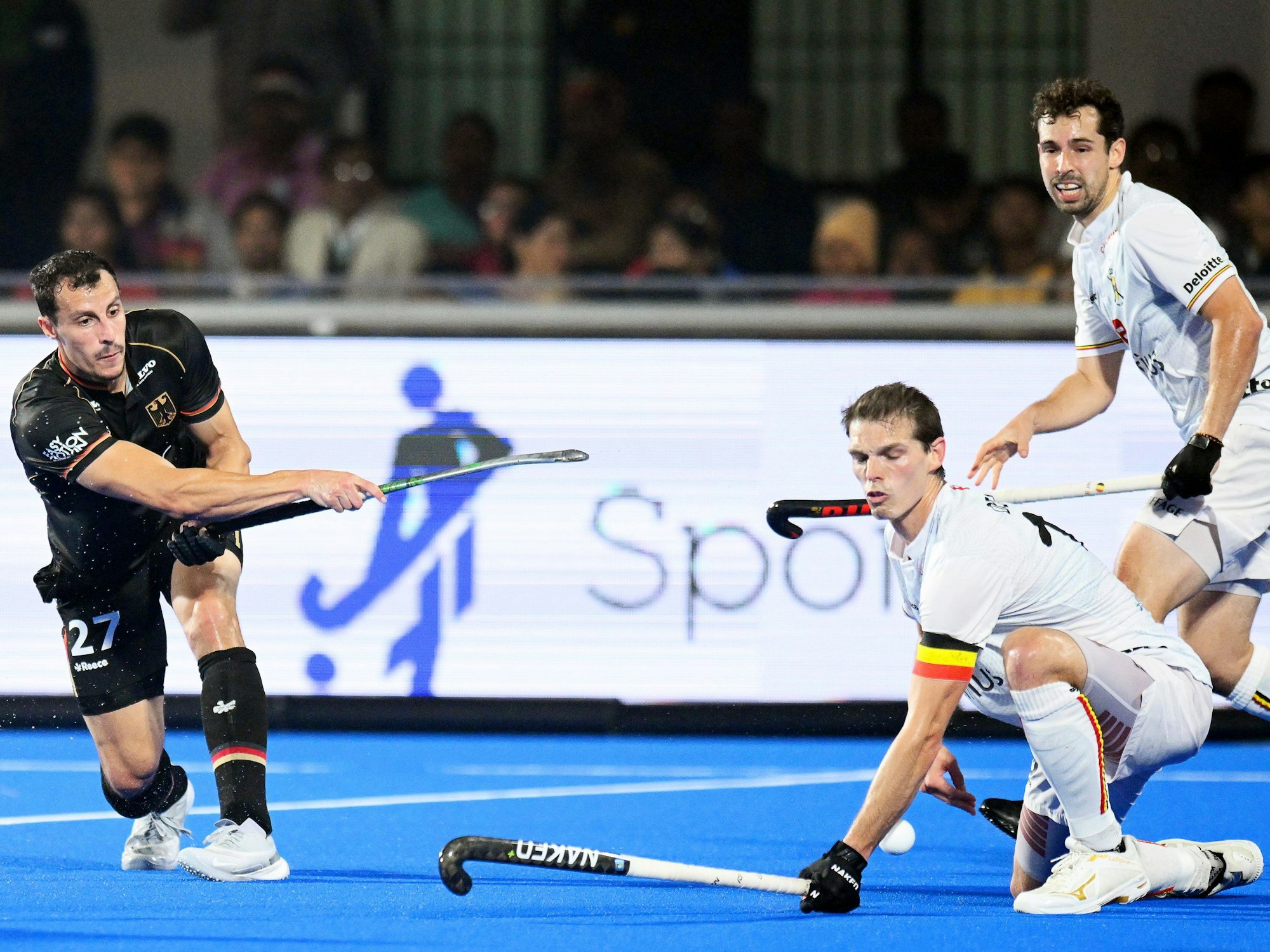 Deutschlands Timur Oruz (l.) schlägt den Ball, Belgiens Spieler versuchen ihn daran zu hindern.