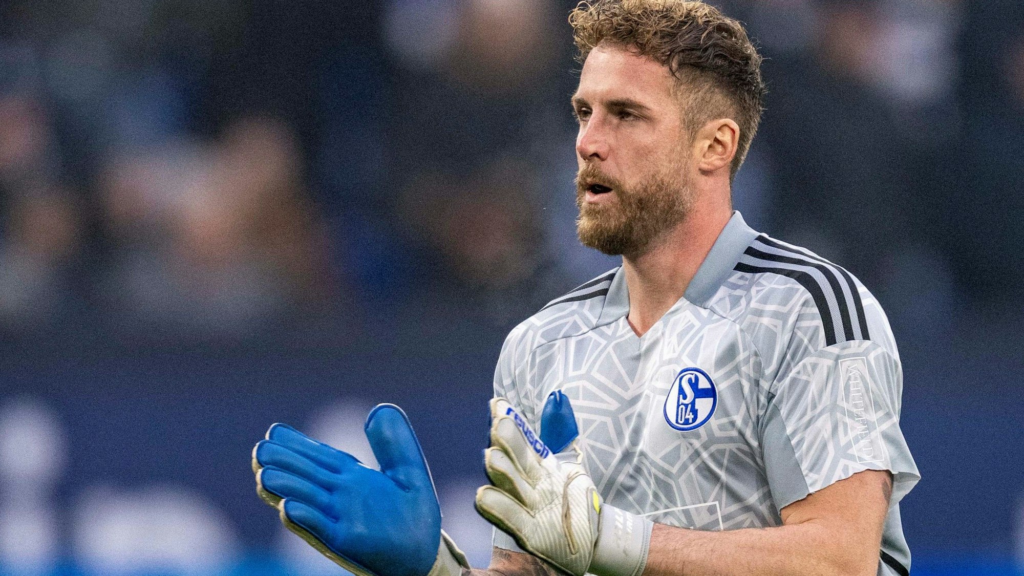 Schalkes Torwart Ralf Fährmann läuft über den Rasen und klatscht in die Hände.