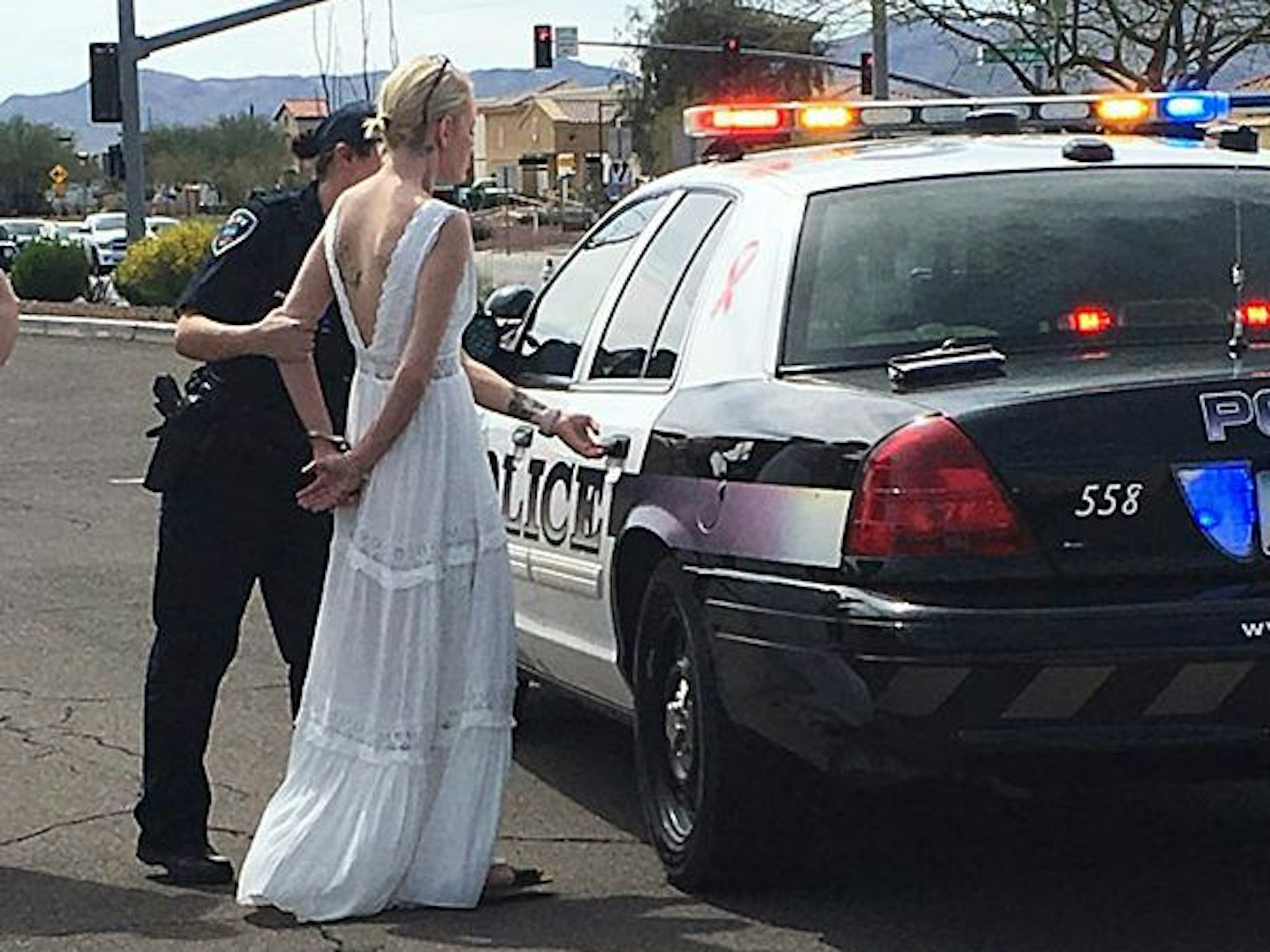 Das vom Marana Police Department veröffentlichte Foto zeigt eine 32 Jahre alte Braut in Handschellen, die von einer Polizistin zum Einsatzfahrzeug geführt wird.