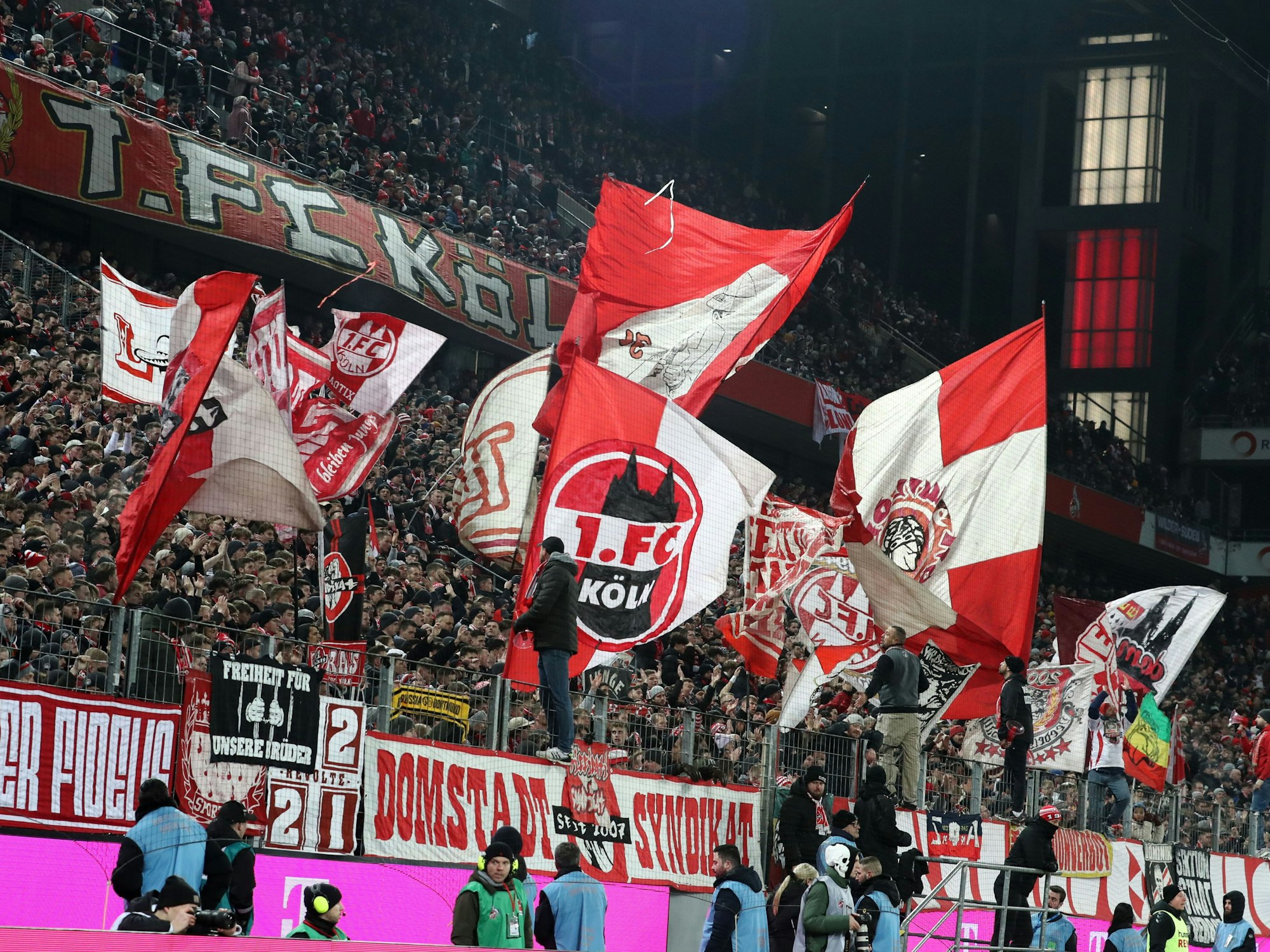 Die Südkurve feiert nach dem Spiel die Mannschaft des 1. FC Köln. In der gefüllten Kurve wehen rot-weiße Fahnen.