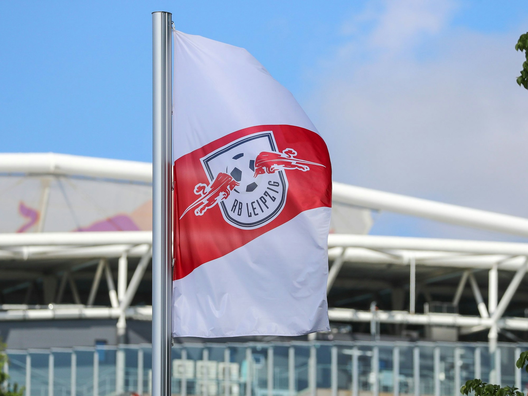 Fußball: Bundesliga, RB Leipzig. Eine Fahne mit dem Logo von RB Leipzig weht vor der Red-Bull-Arena Leipzig.