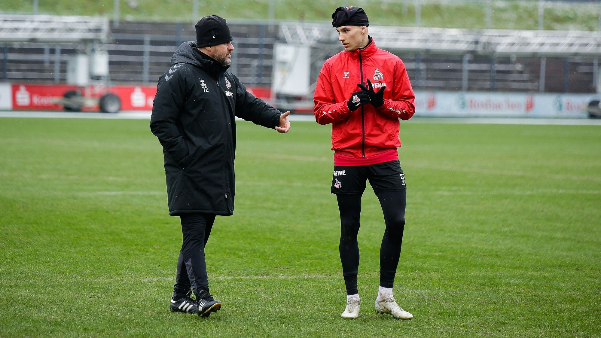 Steffen Baumgart spricht auf dem Rasen des Franz-Kremer-Stadions mit Tim Lemperle.