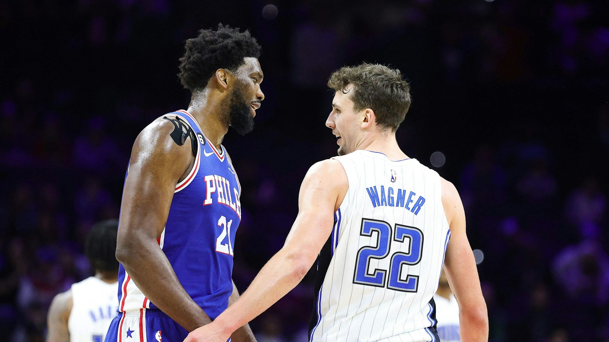 Joel Embiid von den Philadelphia 76ers unterhält sich während eines NBA-Spiels mit Franz Wagner (Orlando Magic).