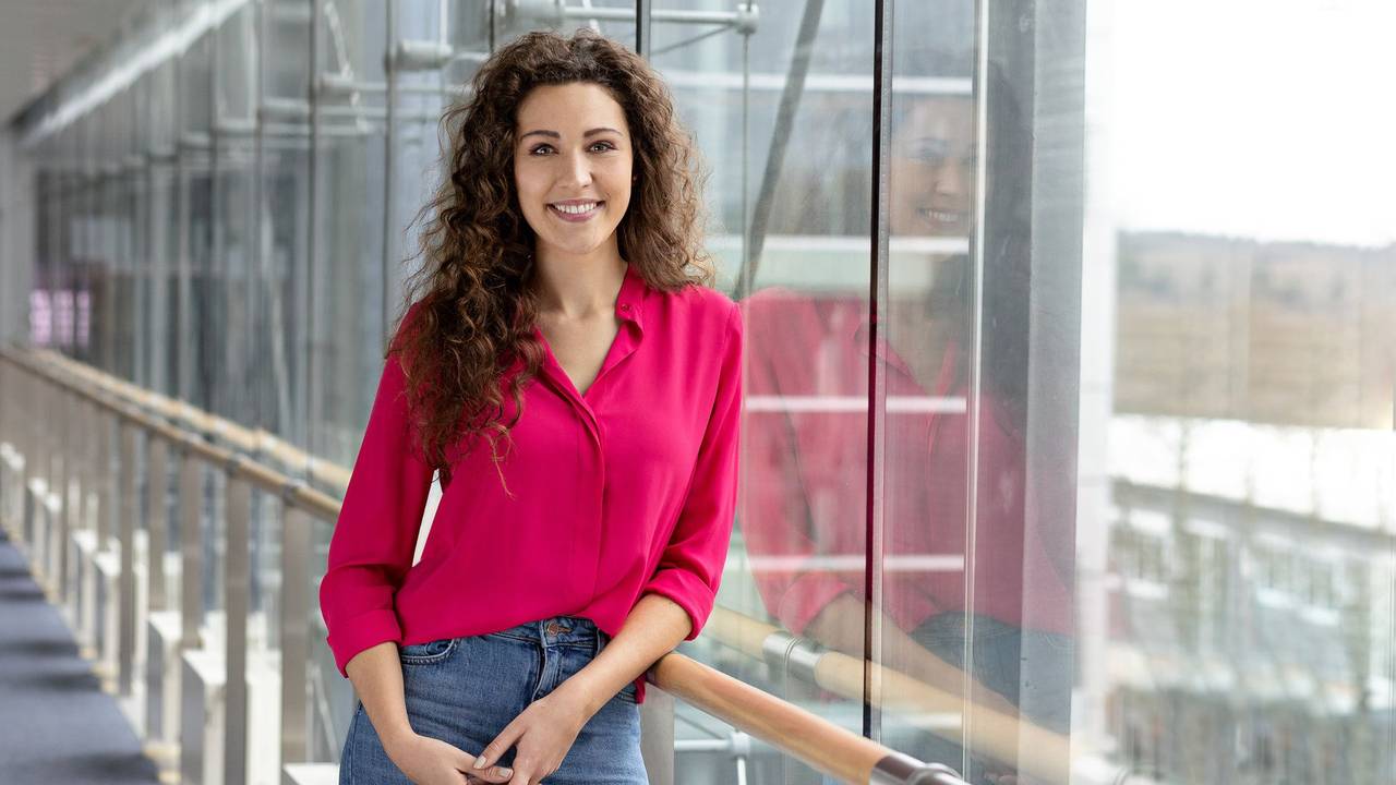 Lena Kesting lehnt an einem Geländer und lächelt in die Kamera.