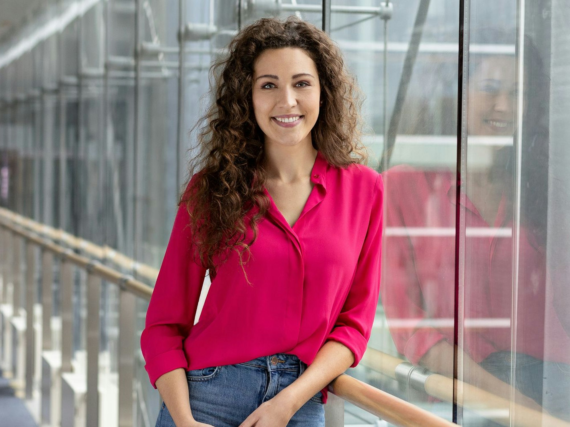 Lena Kesting lehnt an einem Geländer und lächelt in die Kamera.