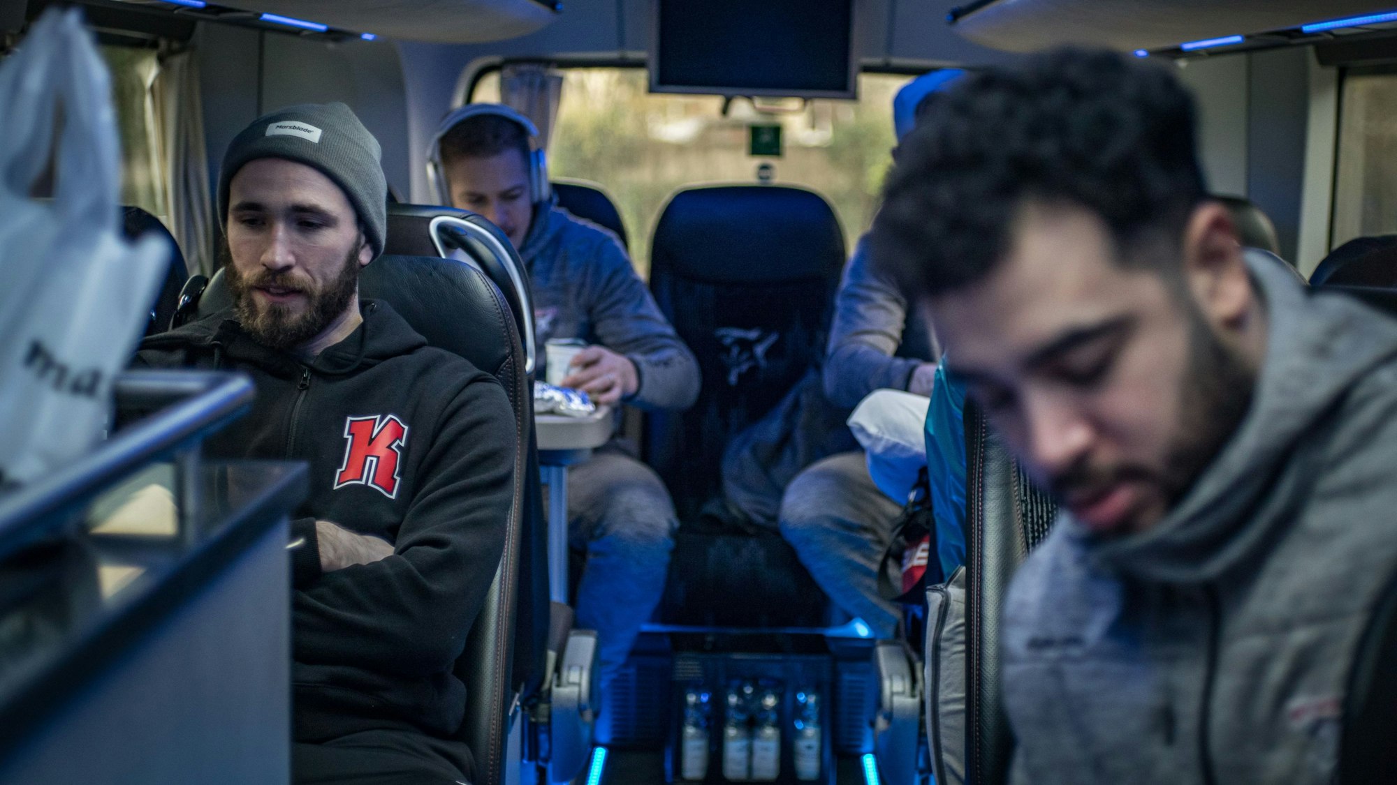 Die Haie-Profis Landon Ferraro, Moritz Müller und Nick Baptiste sitzen im Mannschaftsbus zum Auswärtsspiel in Wolfsburg.