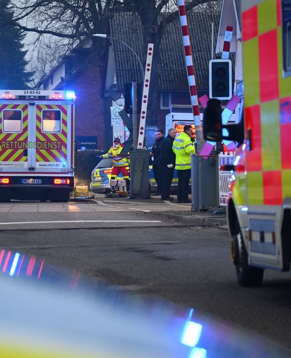 Einsatzkräfte der Polizei und Feuerwehr und Rettungsdienste sind an einem Bahnübergang im Einsatz.