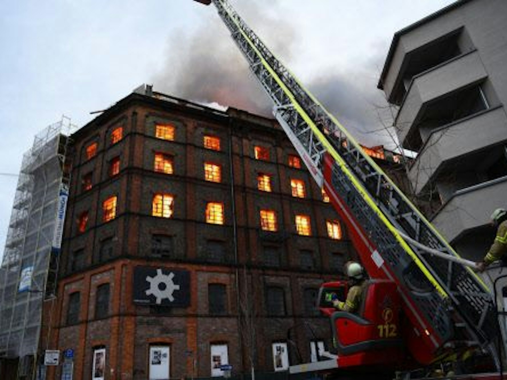 03.02.2023, Baden-Württemberg, Mannheim: Einsatzkräfte der Feuerwehr versuchen von einer Drehleiter aus einen Brand in einem Gewerbegebäude zu löschen.