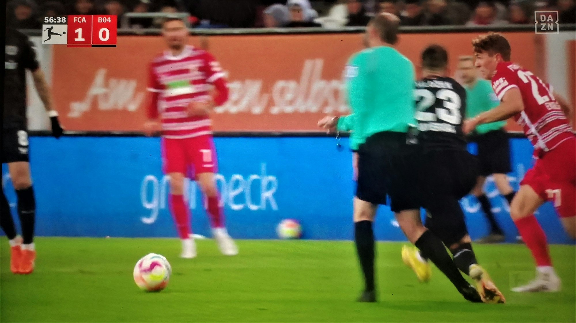 Bayer-Profi Adam Hlozek rennt im Auswärtsspiel beim FC Augsburg in Schiedsrichter Marco Fritz hinein.