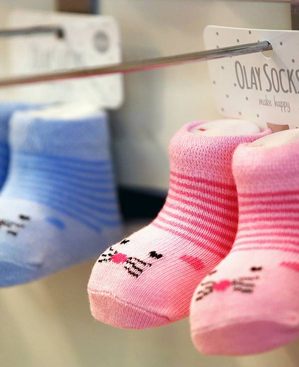 Das Symbolfoto vom 9. Januar 2023 zeigt zwei Paar Babysocken, ein Paar ist rosa, das andere blau.