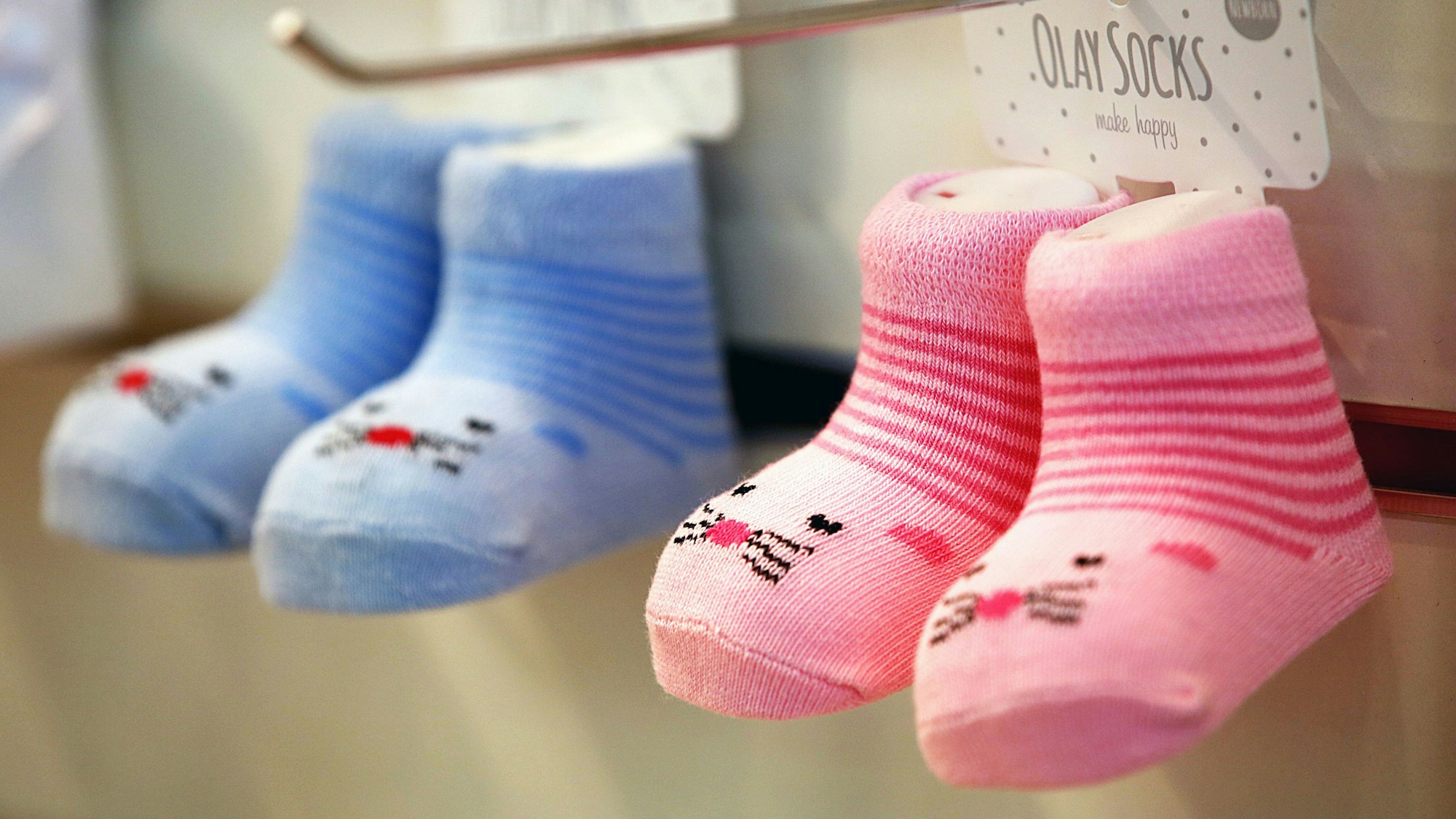 Das Symbolfoto vom 9. Januar 2023 zeigt zwei Paar Babysocken, ein Paar ist rosa, das andere blau.