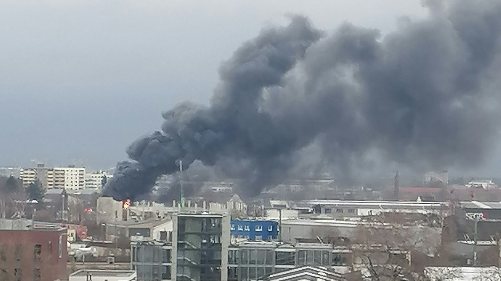 Rauchwolken stehen über einer brennenden Werkstatt in Köln.