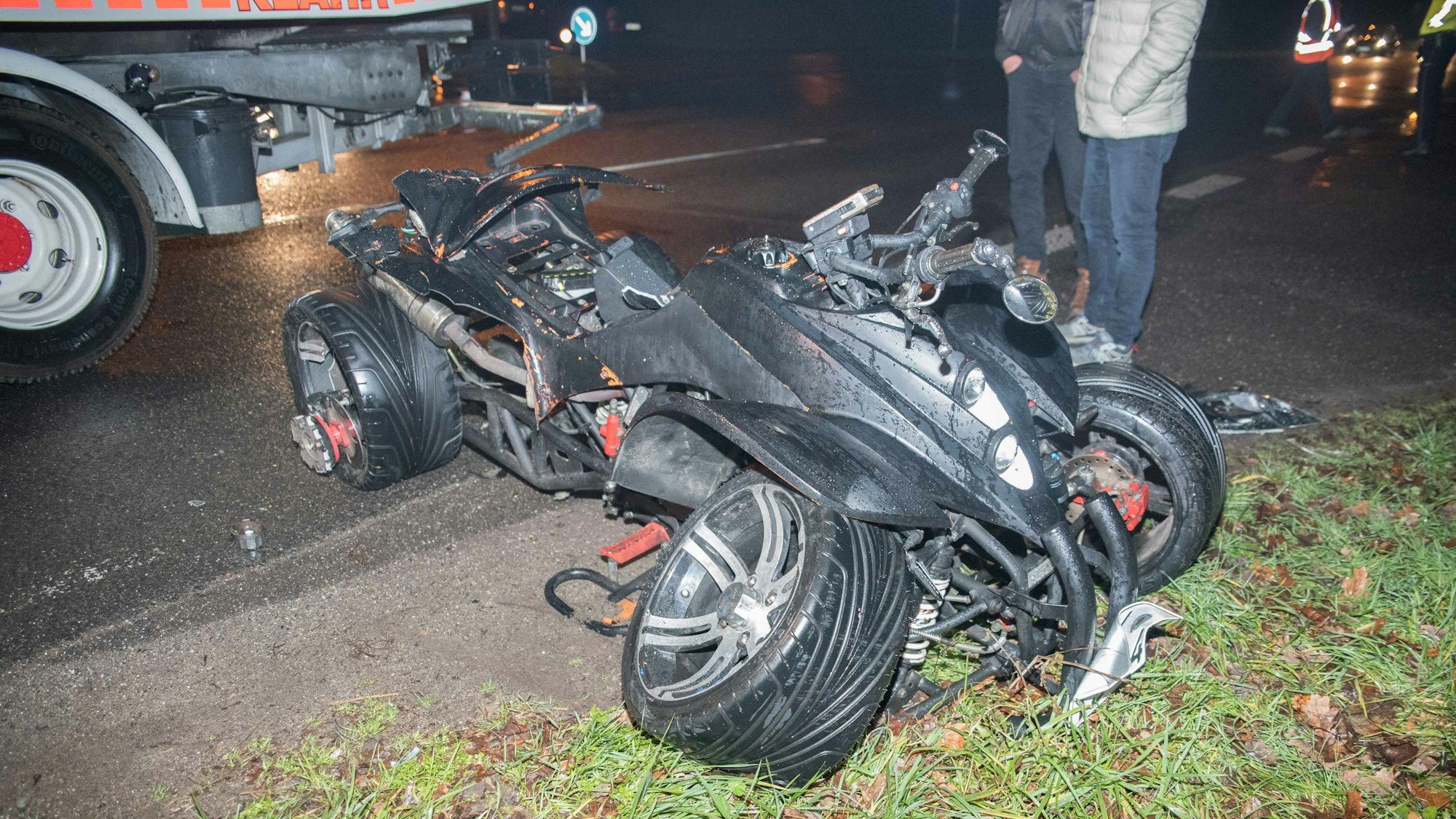 Ein schwer beschädigtes Quad steht halb auf der Straße, hab im Grünstreifen.