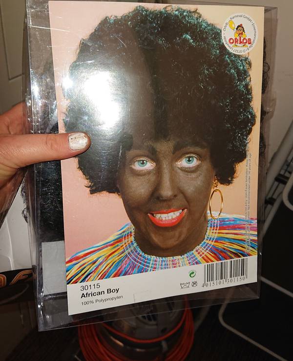 Eine schwarze Perücke als Karnevalskostüm mit der Verpackungsaufschrift African Boy.