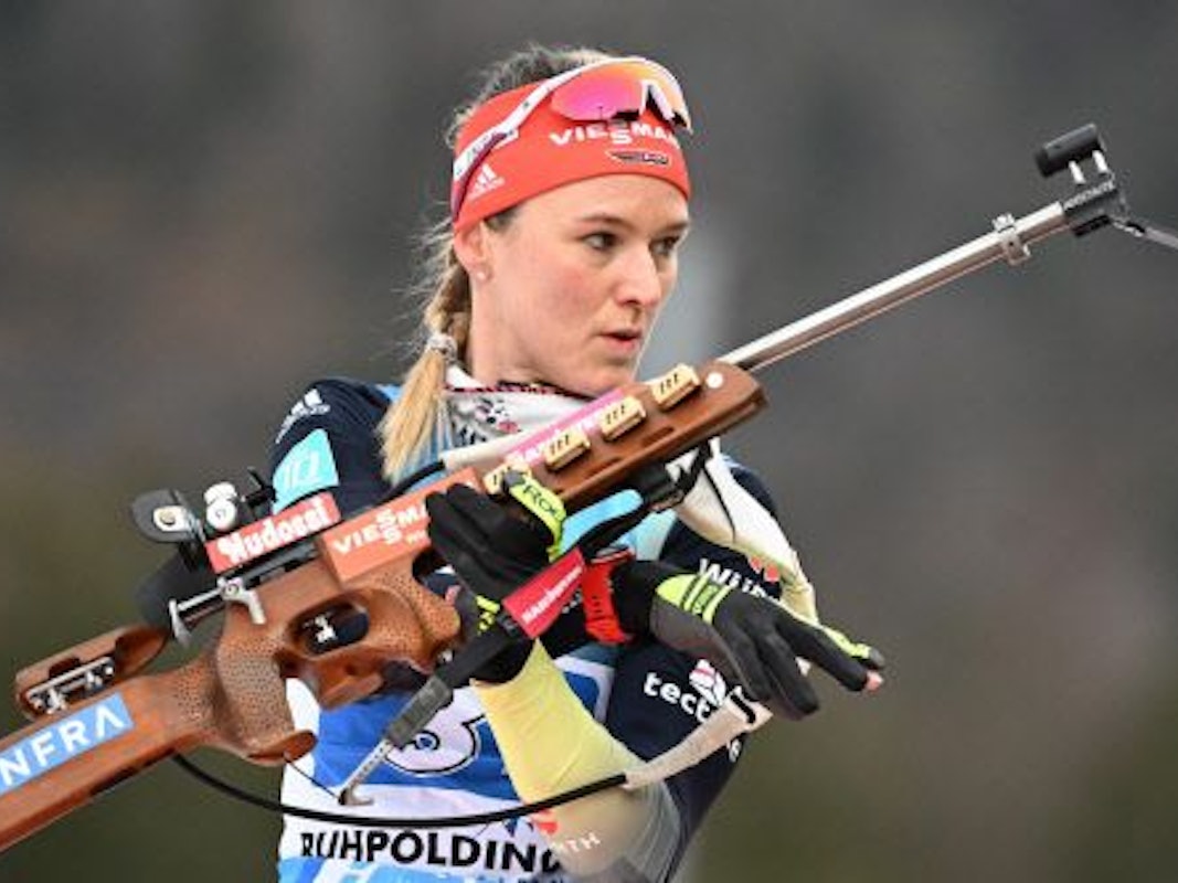 Biathletin Denise Herrmann-Wick steht mit einem Sportgewehr in der Hand am Schießstand in Ruhpolding.