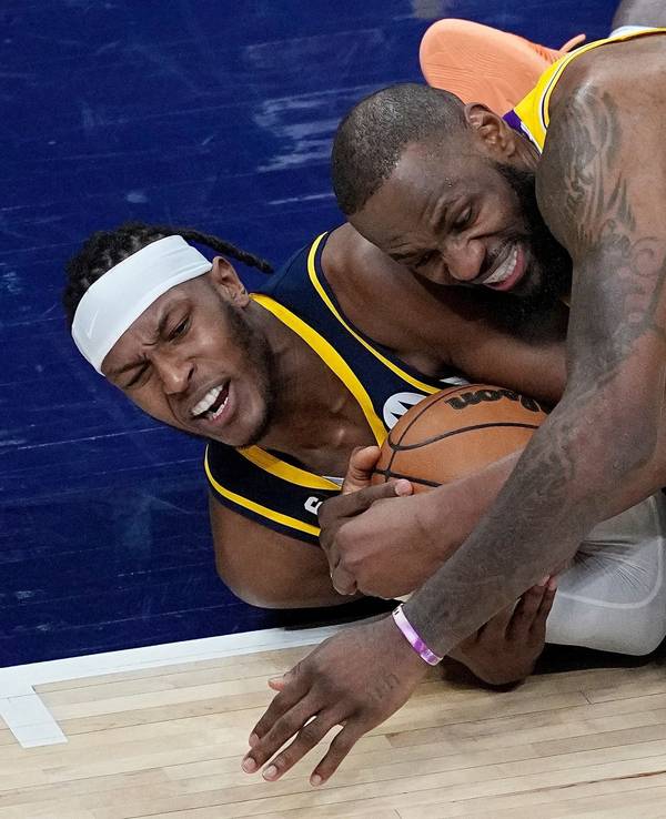 Myles Turner von den Indiana Pacers und LeBron James von den Los Angeles Lakers kämpfen am Boden liegend um den Ball.