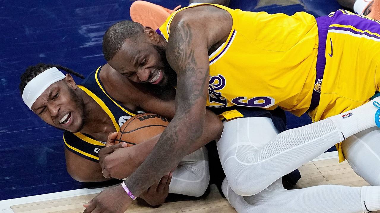 Myles Turner von den Indiana Pacers und LeBron James von den Los Angeles Lakers kämpfen am Boden liegend um den Ball.