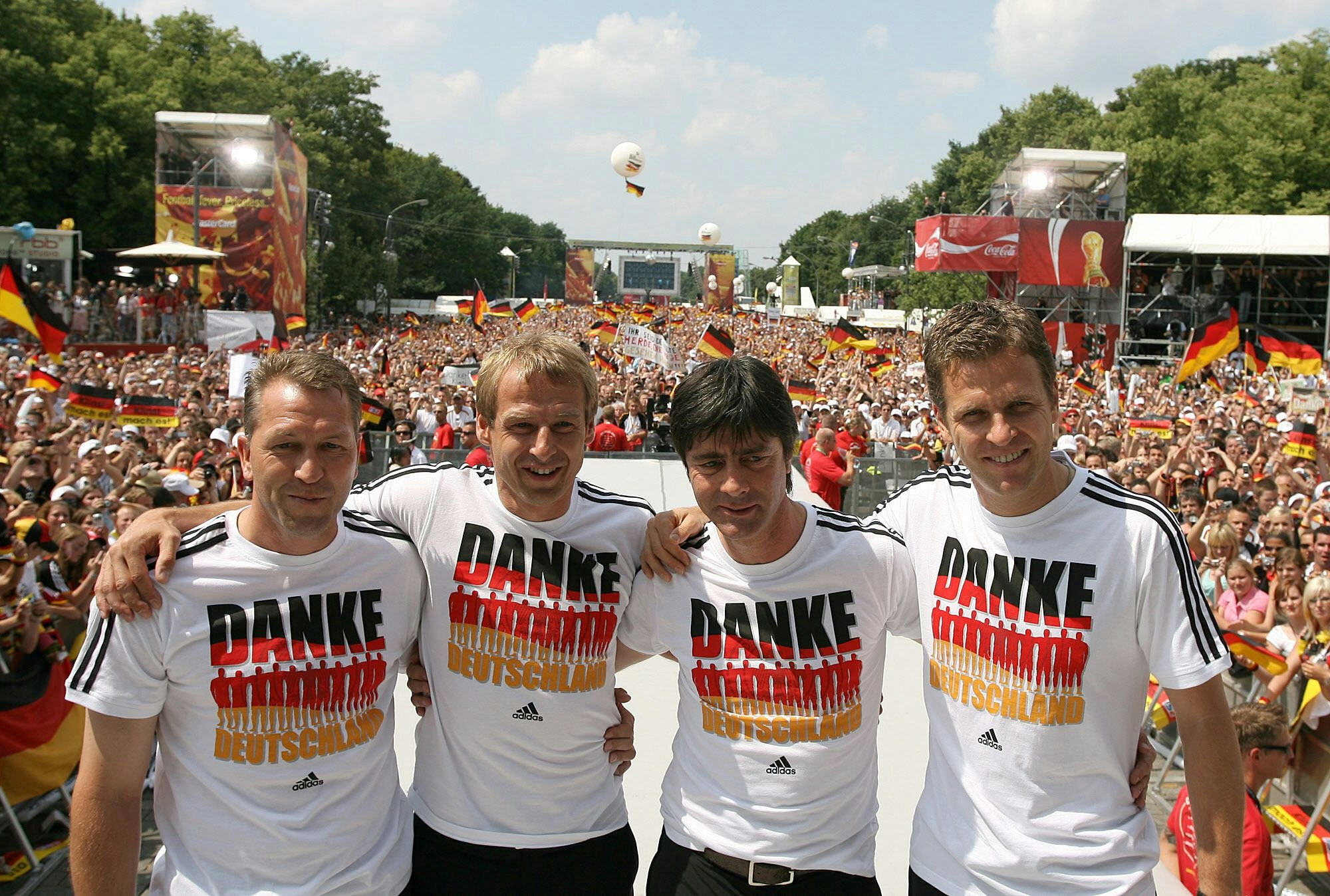 Torwart-Trainer Andreas Köpke, Bundestrainer Jürgen Klinsmann, Co-Trainer Joachim Löw und Team-Manager Oliver Bierhoff stehen auf der Fan-Meile am Brandenburger Tor zusammen.
