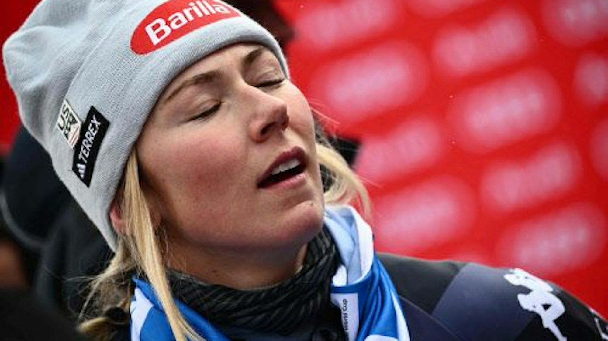 Mikaela Shiffrin steht nach ihrem Sieg beim Riesenslalom in Kronplatz im Zielbereich. Sie trägt eine Mütze und hat die Augen geschlossen.