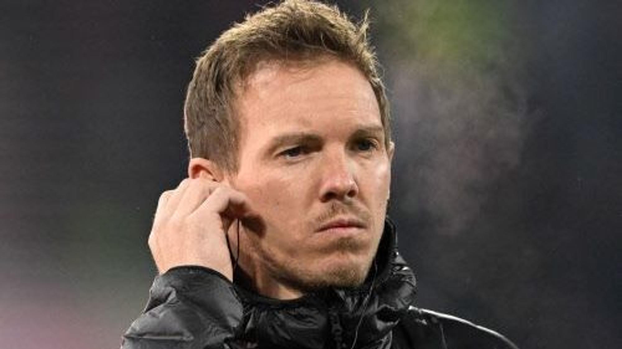 Julian Nagelsmann steht vor dem Spiel gegen Eintracht Frankfurt in der Kälte, er hat einen Knopf im Ohr.