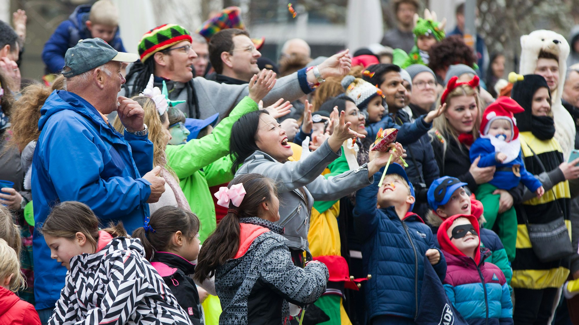 Zuschauer erwarten Kamelle beim Fastnachtsumzug durch die Innenstadt.