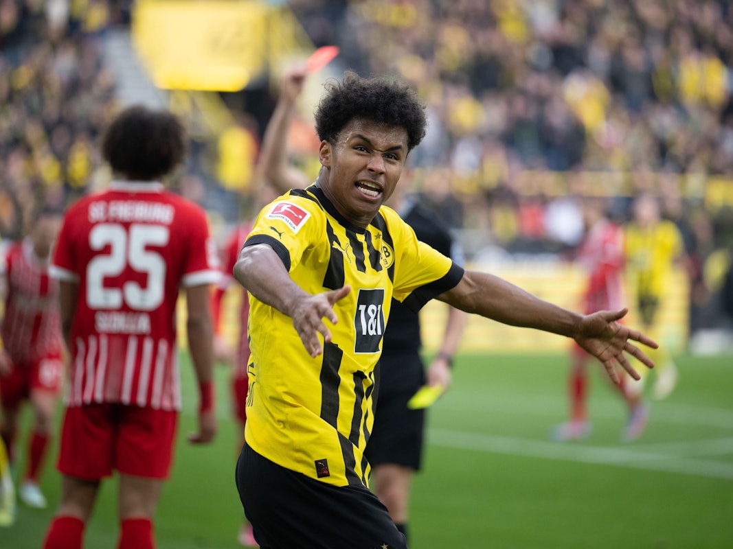 Dortmunds Karim Adeyemi jubelt, während Kiliann Sildillia (l) von Freiburg die Rote Karte sieht.